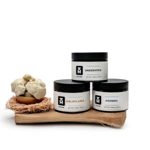 three jars of body butter sitting on top of a wooden board